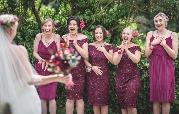 Photo by Ruth Mitchell Photography of bride in front of her bridesmaids who wear purple mismatched dresses