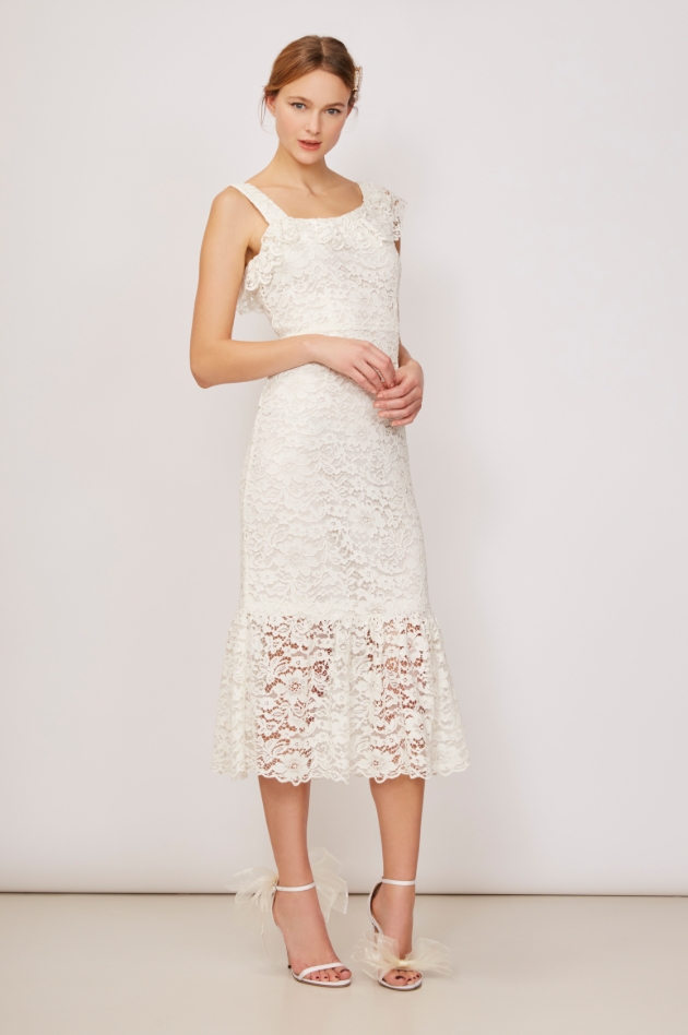 Model is in a studio and wearing an ivory floral lace dress