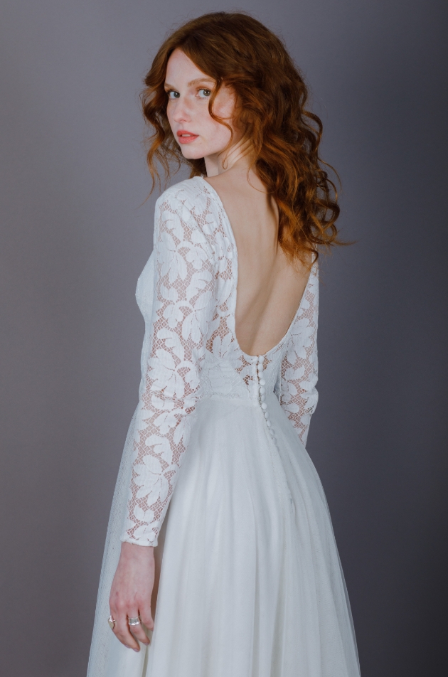 Model wears large lace patterned bodice with sleeves and tulle skirt