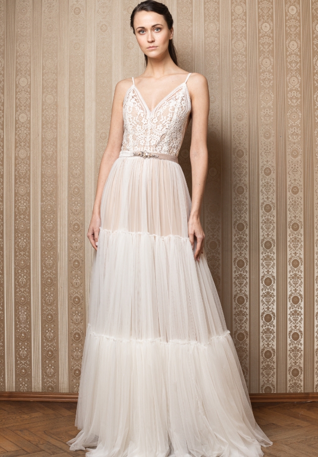 Model wears tiered tulle dress with peach underlay