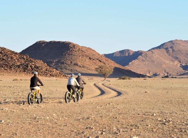 three people on bikes in the desert