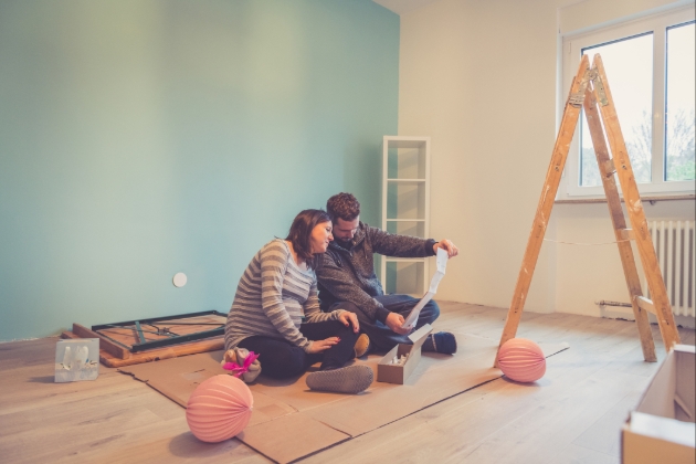 couple in room which is being decorated and the woman is pregnant