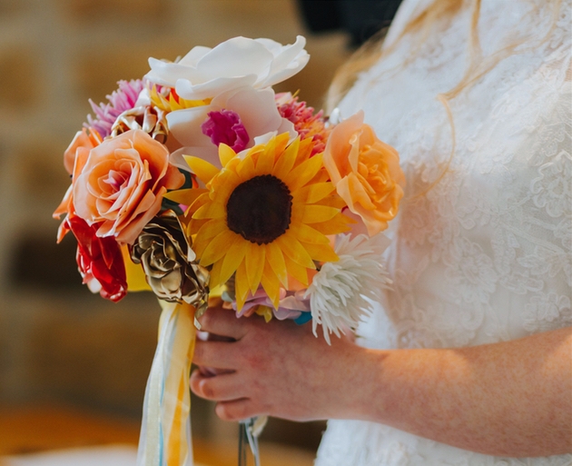 Bride holding a bright wedding bouquet of sustainable repurposed plastic flowers