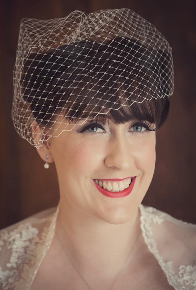 Close up of bride wearing a birdcage veil with vintage style make up