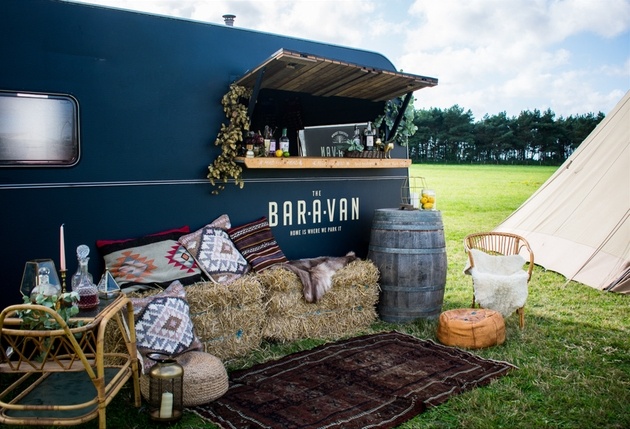 Mobile bar set up in field next to tipi with cocktails and seating