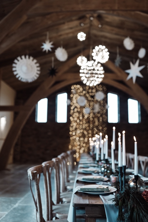 Table set in winter style with candles and fairy lights for micro wedding.