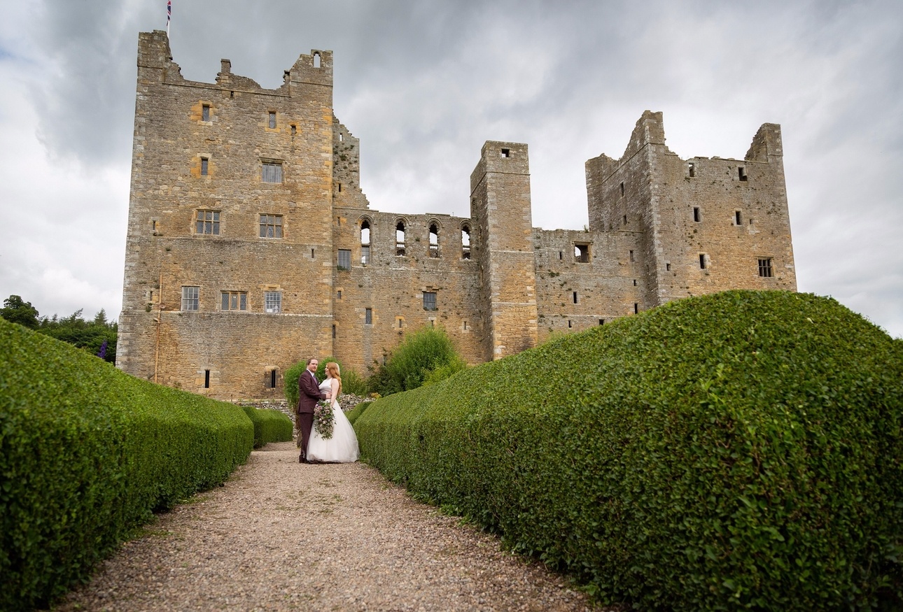 Newlywed couple outside fairytale wedding venue Bolton Castle.
