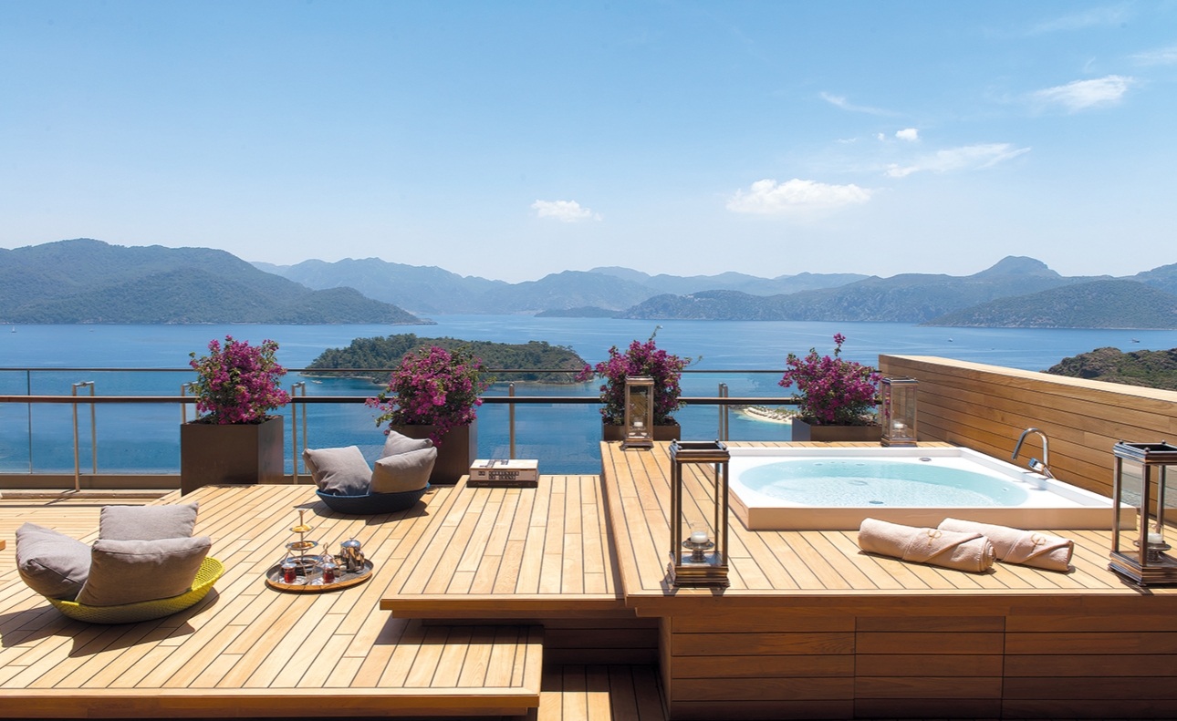 sun drenched terraced with lounger and pool looking out to ocean 