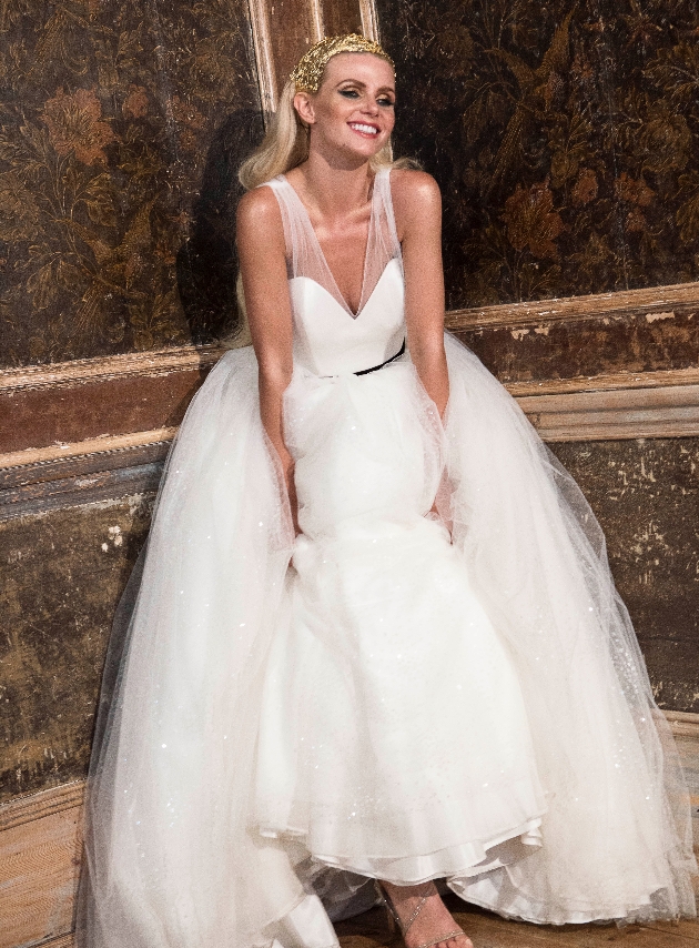 model wearing white dress with black belt and gold crown