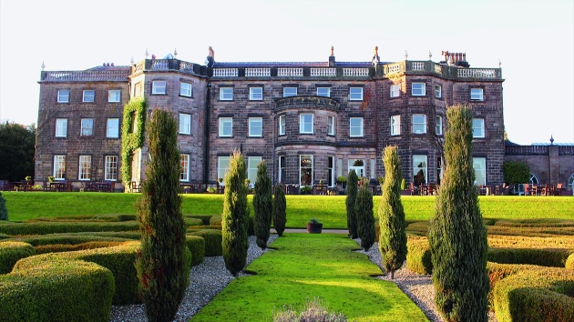 grey brick historic country manor house with manicured grounds 