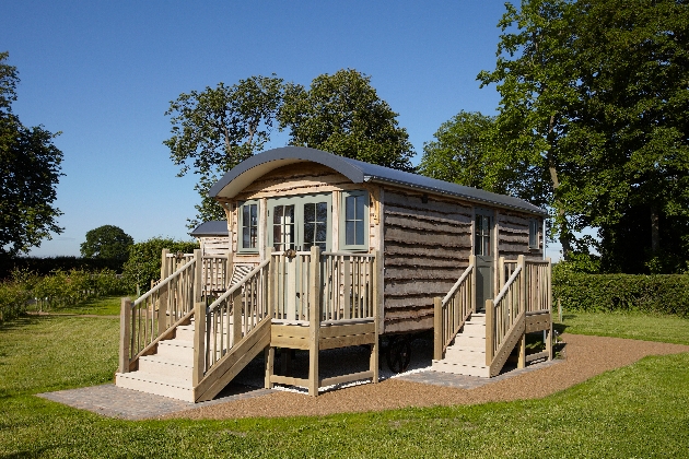 shepherd hut on grass surrounded by trees