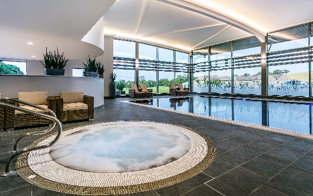 whirlpool jacuzzi in a spa and pool area with panoramic windows