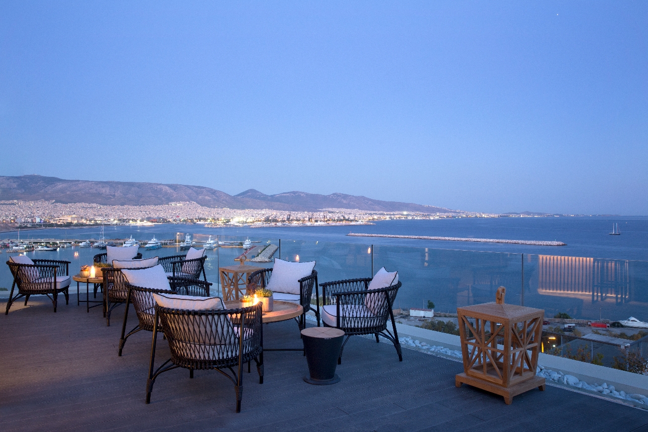 Chairs on a terrace in the evening looking out to sea and mountains