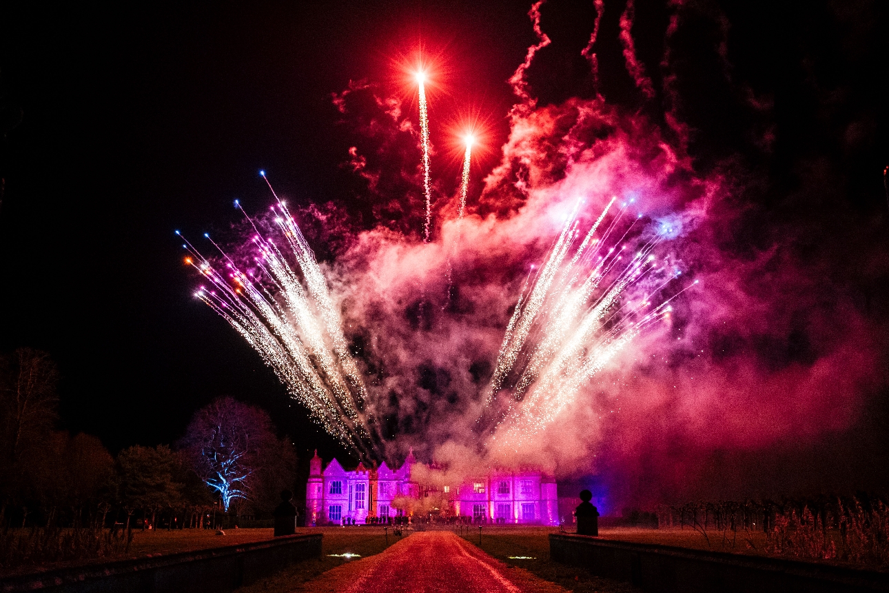 manor house at night with firework display going off above