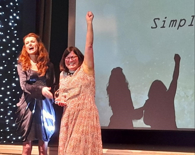 two women on stage winning award