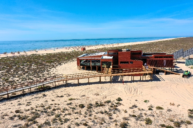 wooden restaurant on stills in the desert sands blue skies