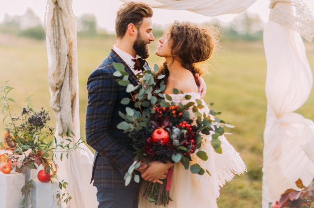 couple in wedding attire standing outside