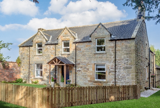 grey stone cottage with fencing 