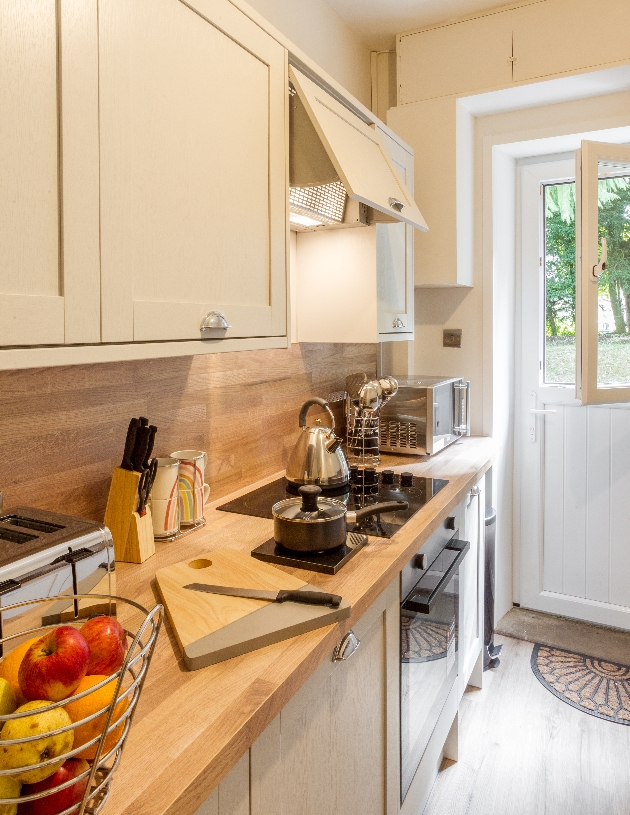 cream kitchen modern units with wood splash back 