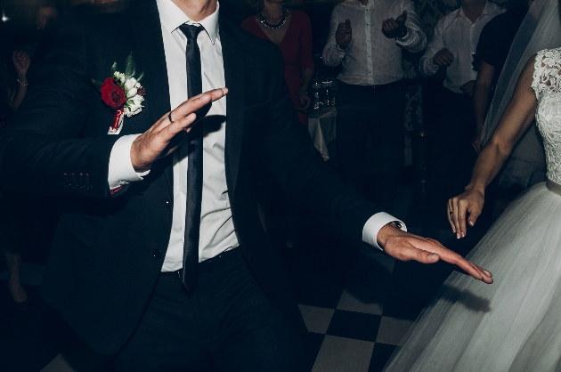 torso of groom dancing at wedding