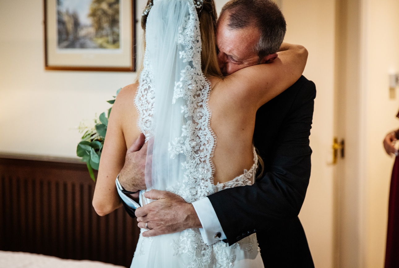 Father hugs bride