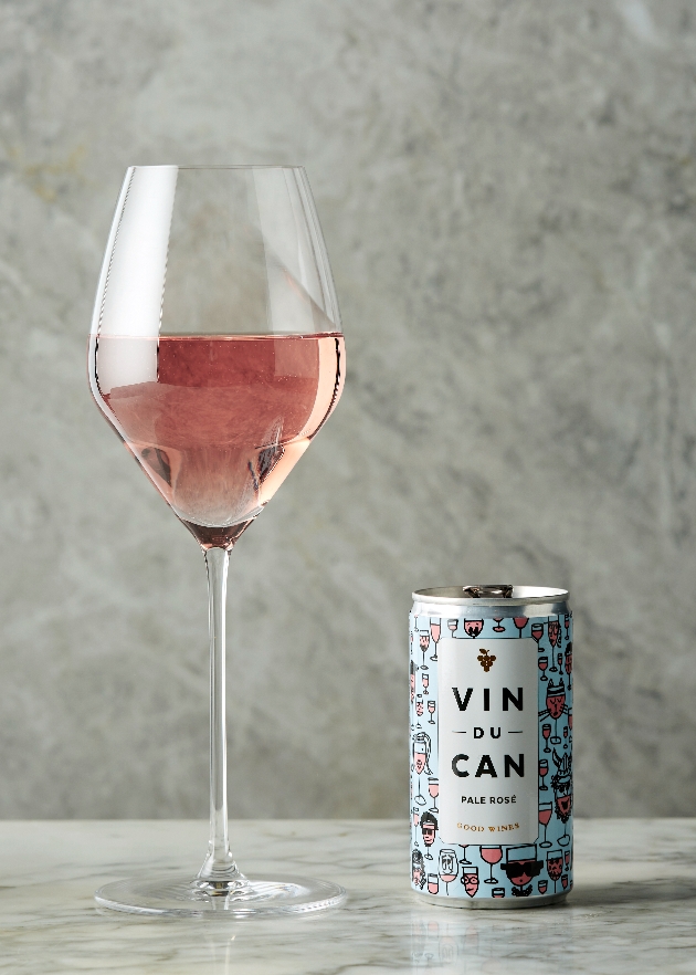 rose wine in a glass with a can next to it