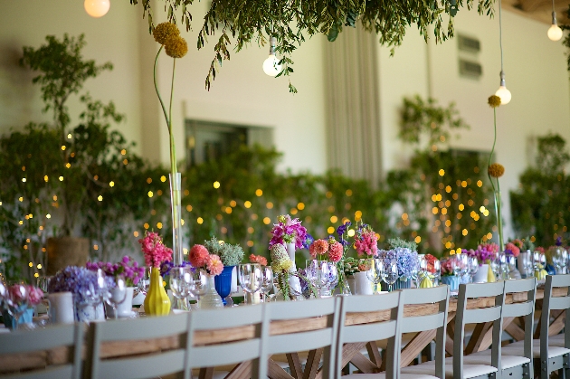 trestle table with flowers and vases in all different colours