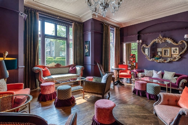 cosy interior of hotel sitting rooms with plush chairs and deep purple walls