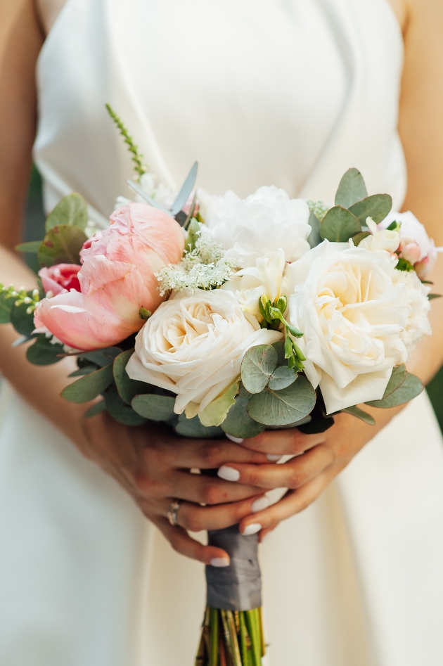 bride holding a bouquet of cream and pink flowers