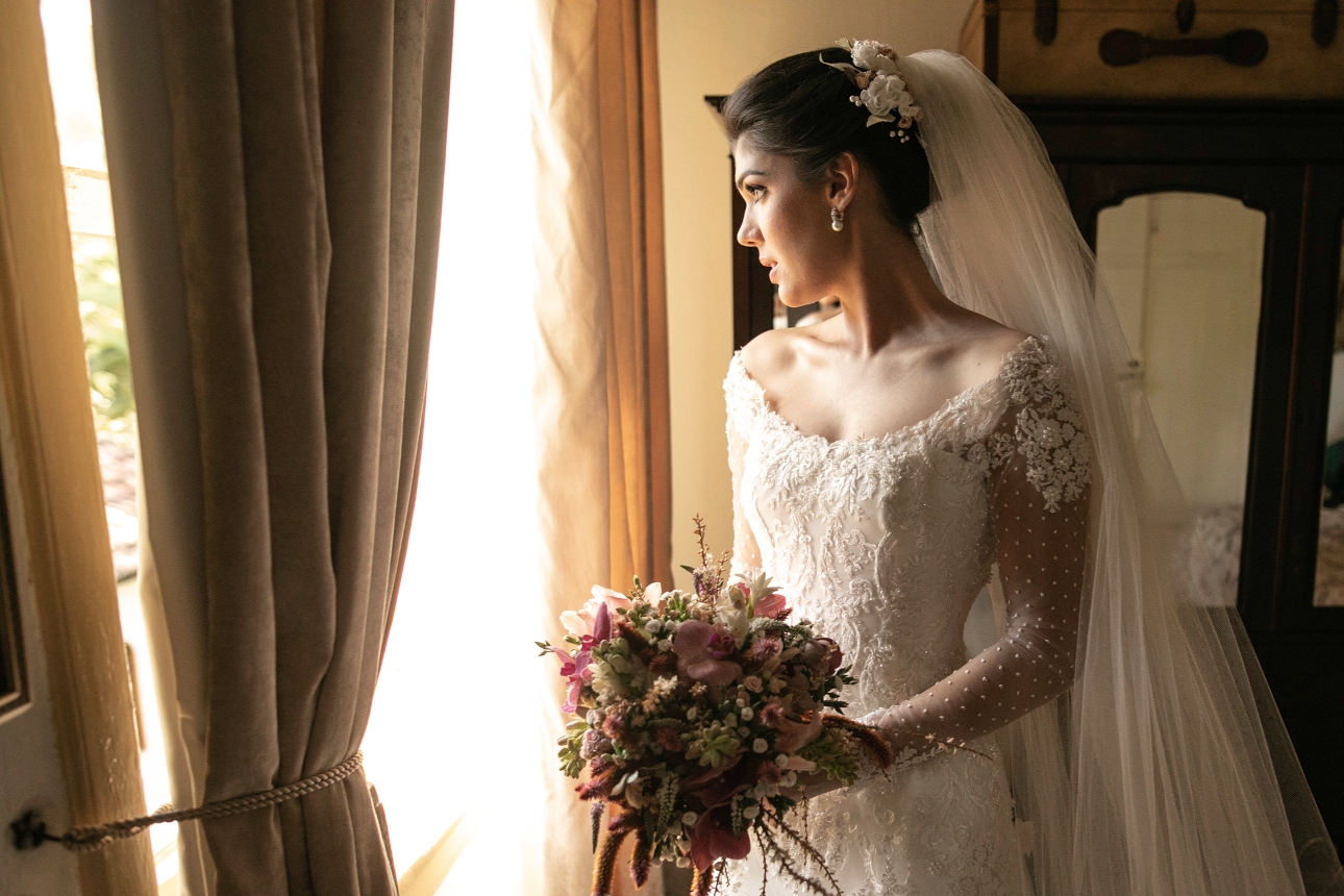 bride in wedding dress looking out window nervous