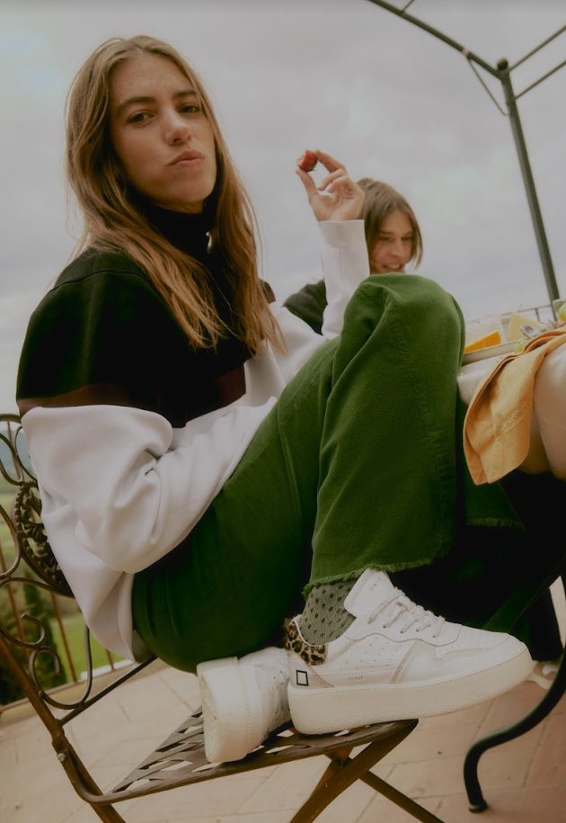 attractive woman crouched at table wearing cool sneakers