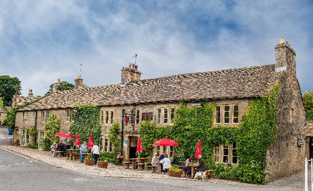 cosy brick pub exterior with guests sat outside