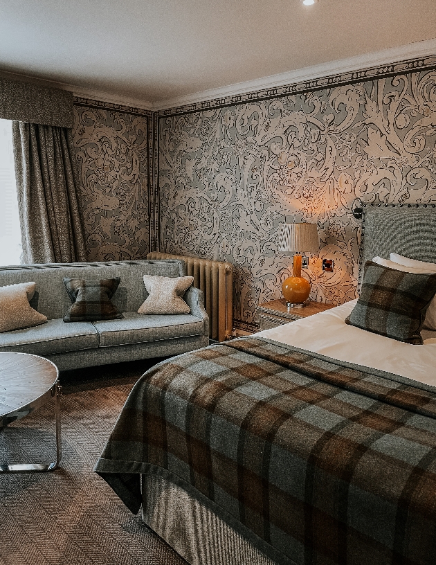 luxury hotel bedroom with bed with tartan throw