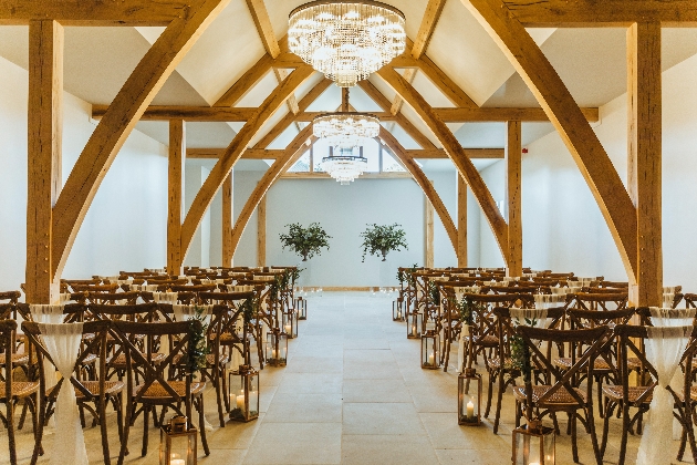 new oak framed barn interior with chairs set up for wedding