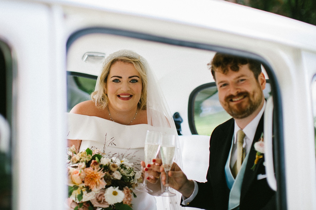 Newlywed drinking champagne in taxi