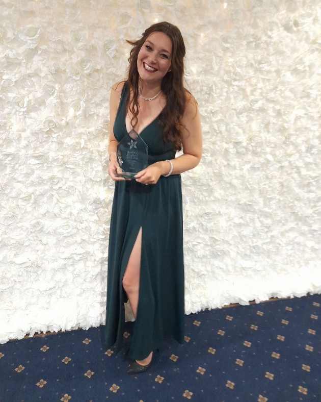 Charlotte Elizabeth Photography holding her award at awards ceremony