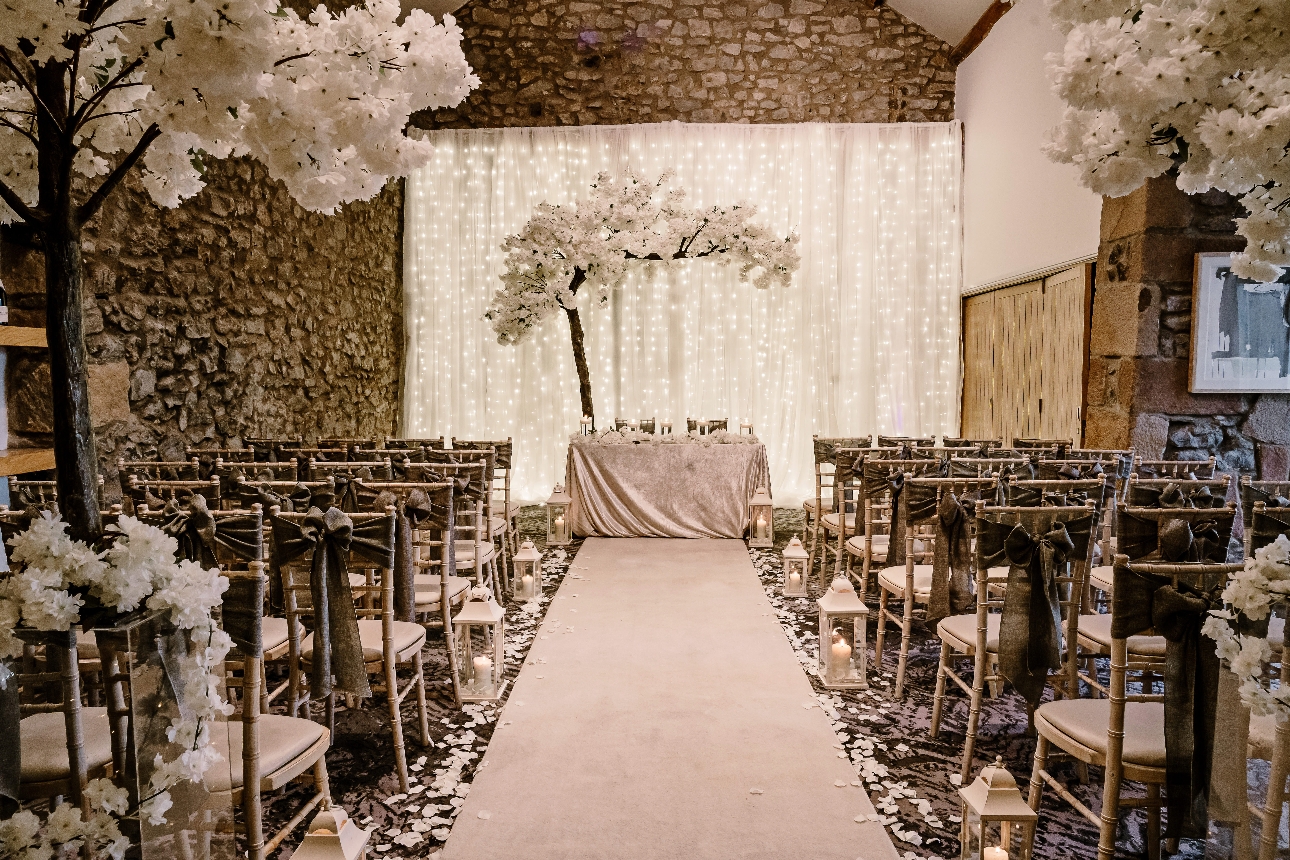aisle with blossom tree at end in front of white backdrop 