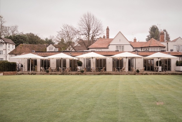 hotel with terrace and chairs on it facing large lawn