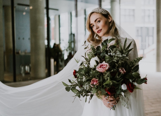 model in high neck long sleeved dress holding giant bouquet