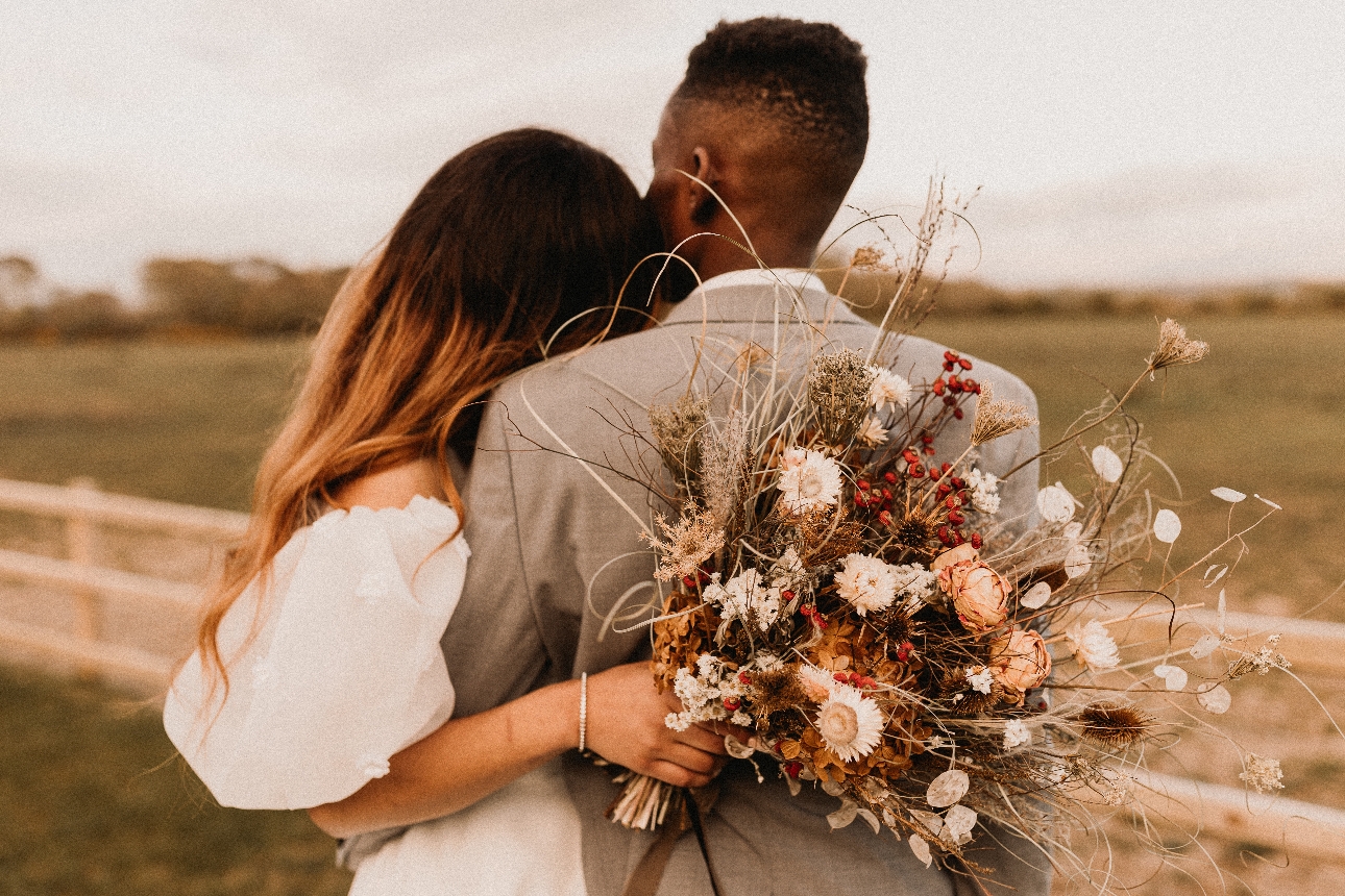 wedding couple embracing looking out to fields