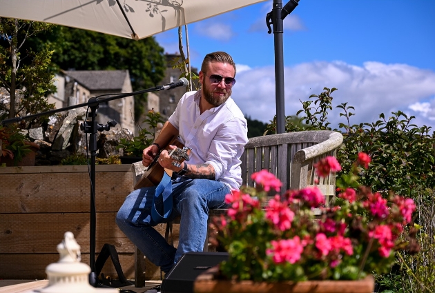 Leon Marshall, musician, playing guitar in sun