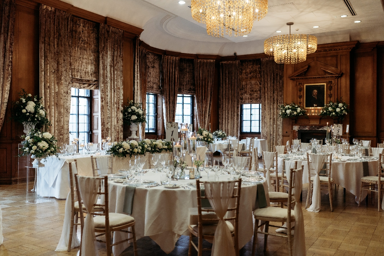 large ornate room with reception tables and chandeliers