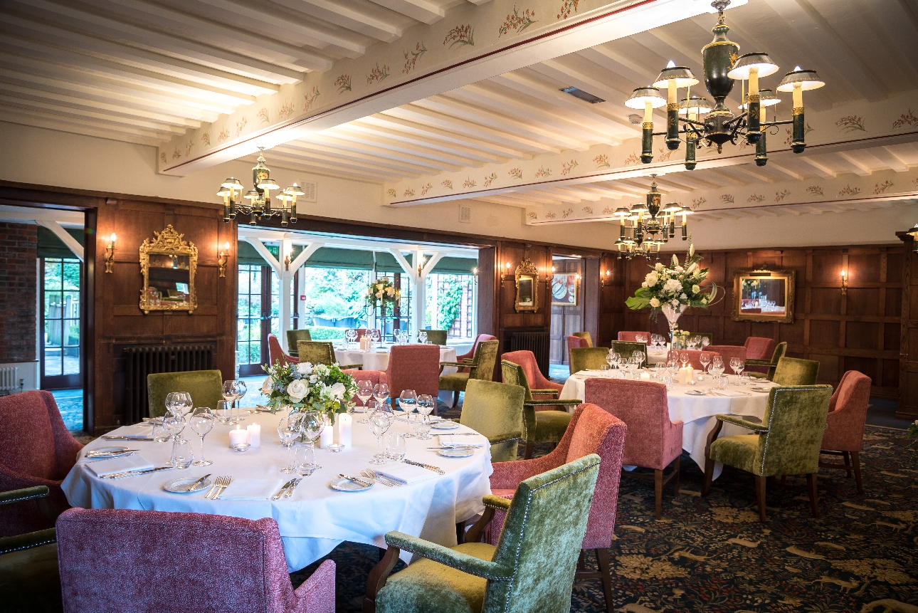 wood-panelled restaurant, beamed ceilings, pink and green velvet chairs