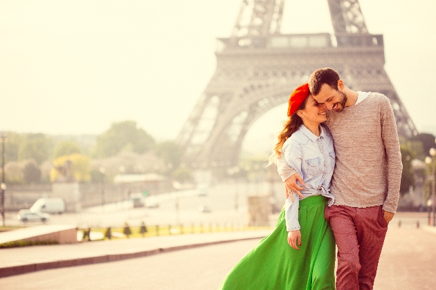 Couple cuddling in front of the eiffel tower