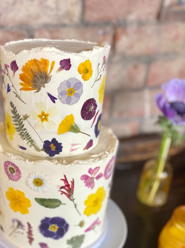 two tier white cake with pressed flowers