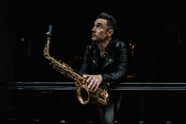 Simon Levi holding a saxophone