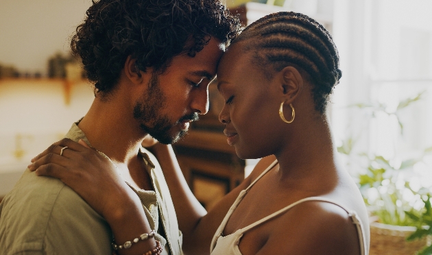 man and woman foreheads touching in kitchen