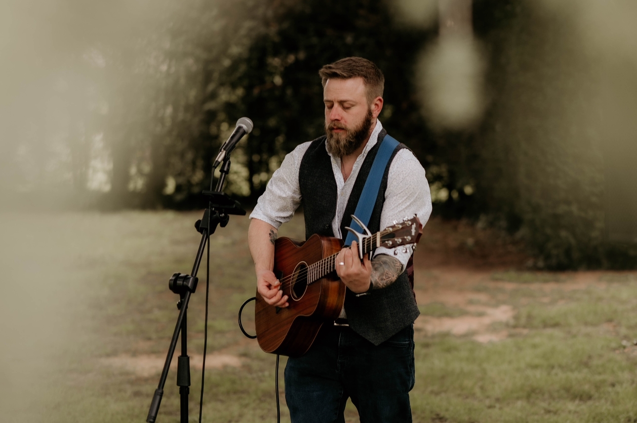 Leon Marshall with guitar performing outside