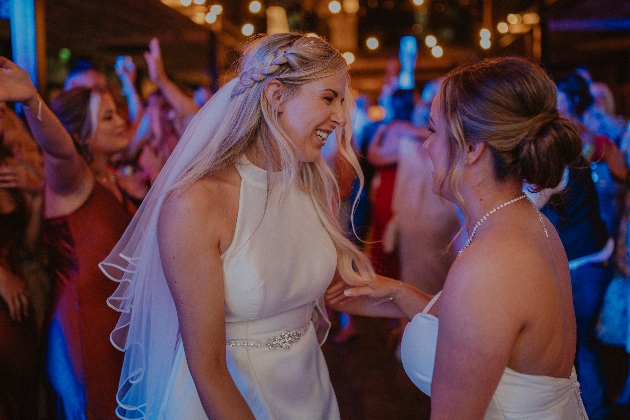 wedding brides on dancefloor with their guests