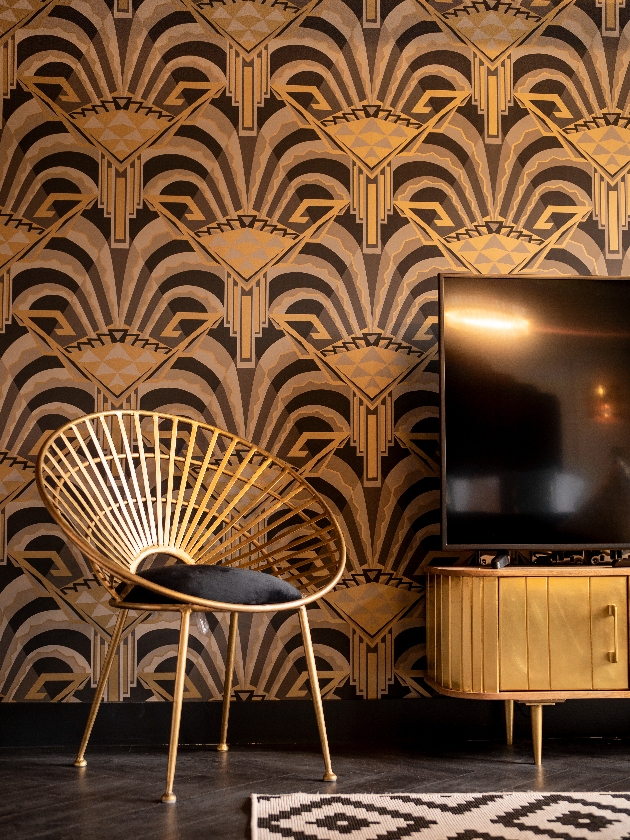 art deco style room with gold wallpaper and chair